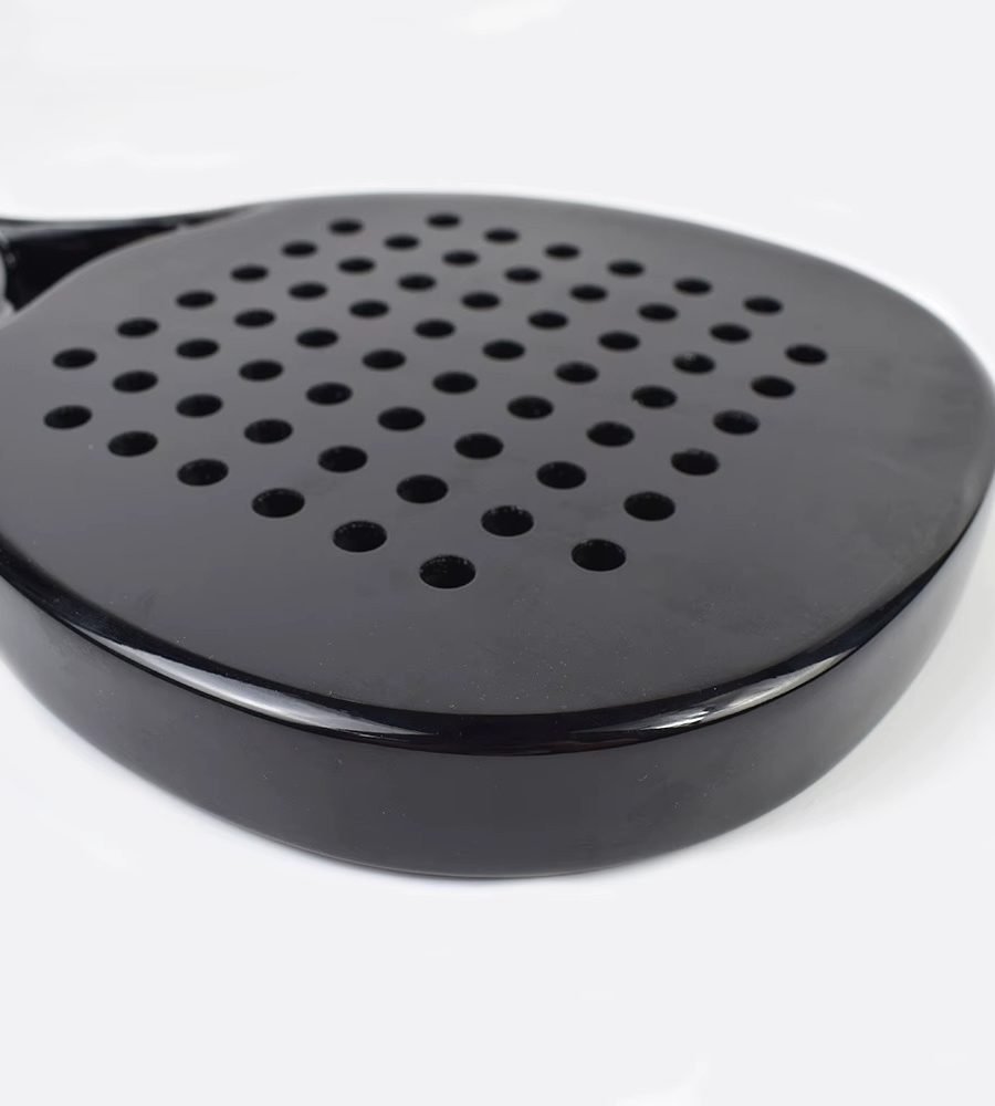 Close-up of a carbon racket face with drilled holes